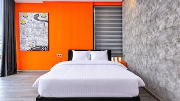 Un dormitorio moderno con una cama grande, una pared de acento naranja, una obra de arte con un paisaje urbano y una pared texturizada gris.