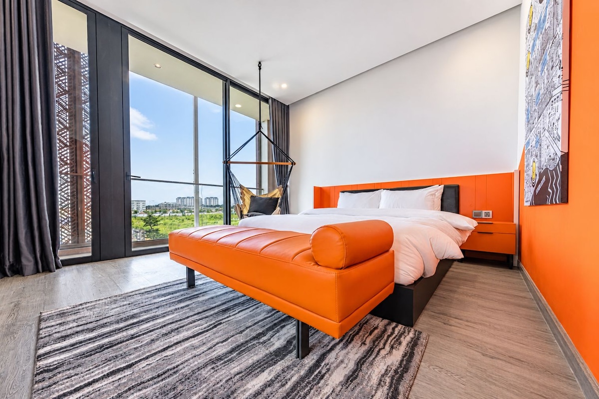 A modern bedroom with a large bed, a view of the city, and a balcony.
