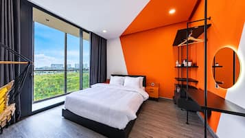 Un dormitorio moderno con una cama grande, vista a la ciudad y una pared de acento naranja singular.