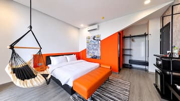 Una habitación de hotel moderna con una cama, una silla colgante, un armario y un escritorio.