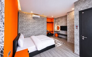 A modern hotel room with a bed, a TV, and a wardrobe.