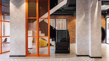 Un interior moderno con una escalera, pared de ladrillo y suelo estampado.