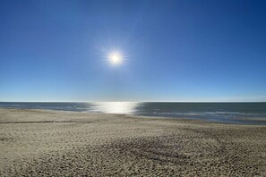 Ein Strand mit blauem Himmel und Sonnenschein.