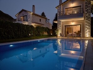 A modern two-story house with a swimming pool, stone exterior, and outdoor seating area. - Avesta Private Villas Niovi (Lefkada)