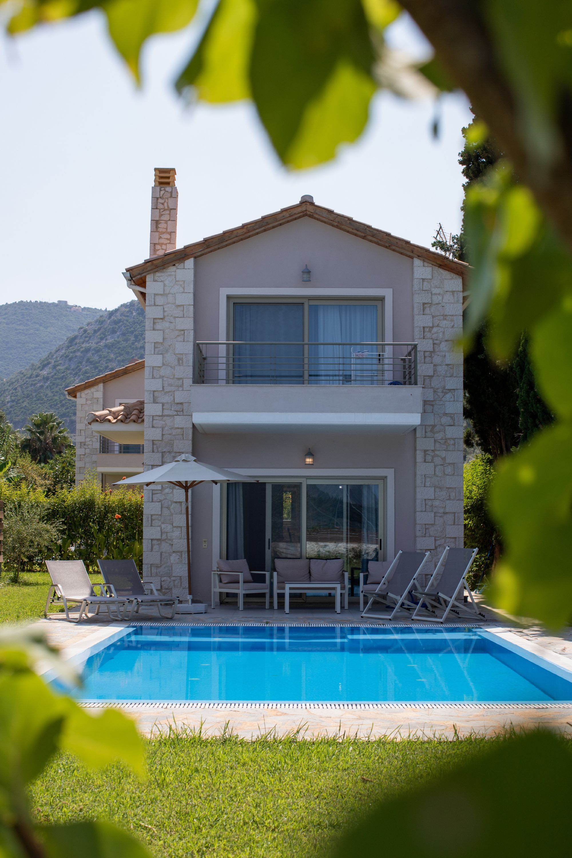 Un bâtiment à deux étages doté d’une piscine, d’un espace extérieur aménagé et offrant une vue sur les montagnes.