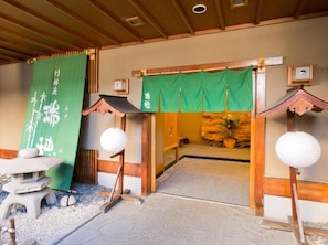 Een traditioneel Japans interieur met tatami vloerbedekking, shoji schermen en een stenen lantaarn.
