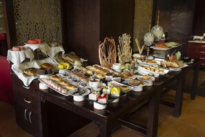 Una mesa de buffet con diferentes alimentos y un fondo decorativo.