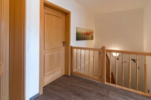 A wooden door, a staircase with a wooden railing, and a wall-mounted painting. - 9/T6 holiday home park “Freesenbruch” (Zingst (Ostseeheilbad))