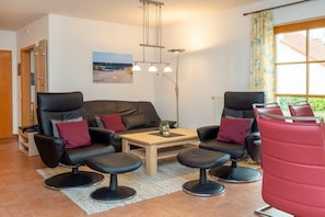 A modern living room with a sofa, two armchairs, a coffee table, and a red barrel. - 7/T5 holiday home park “Freesenbruch” (Zingst (Ostseeheilbad))