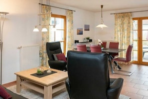 Ein modernes Wohnzimmer mit Essbereich, ausgestattet mit einer Couch, einem Esstisch und Stühlen.