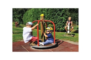 Due bambini giocano su un’attrezzatura da parco giochi con base circolare e un palo centrale.