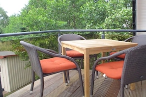 An outdoor deck with wicker furniture and a wooden table. - Mühlenstraße 19 Apartment 4 (Seeheilbad Zingst)