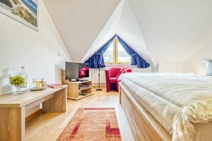 A bedroom with a bed, a desk, a TV, and a window with curtains. - 6a/T5 in the "Freesenbruch" holiday park (Zingst (Ostseeheilbad))