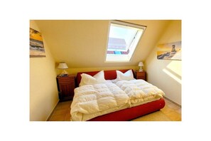 A bedroom with a bed, a skylight, and a nightstand. - Residence on the Beach 2-39 (Zingst (Ostseeheilbad))