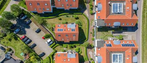 A residential complex with multiple brick buildings, solar panels, and a parking area.