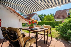 An outdoor patio with a table, chairs, and a flower arrangement. - 6/T5 holiday home park “Freesenbruch” (Zingst (Ostseeheilbad))
