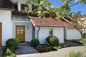 A two-story house with a tiled roof, a front door, and a small porch area. - 7a/T5 in the holiday apartment park "Freesenbruch" (Zingst (Ostseeheilbad))