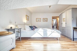 A bedroom with a bed, bedside table, wardrobe, and a view of a hallway. - 7a/T5 in the holiday apartment park "Freesenbruch" (Zingst (Ostseeheilbad))