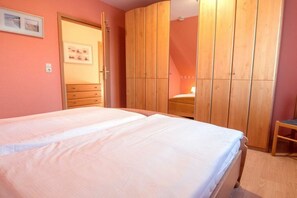 Ein Schlafzimmer mit einem Doppelbett, einem Holzschrank und einem kleinen Tisch.