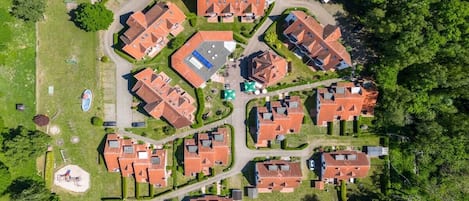 Vista aérea de uma área residencial com várias casas, ruas e áreas verdes.