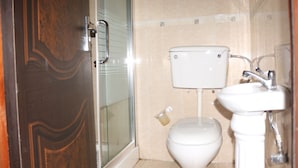 Une salle de bain avec des toilettes, un lavabo et une douche.