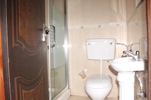 A bathroom with a toilet, sink, and shower. - Phisbond Hotels (Uyo)