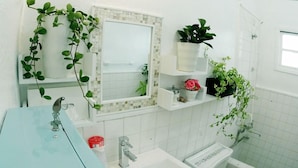 A bathroom with a sink, mirror, and shelves with plants. - Okinawan. Sweet Home.t-8 (Chatan)