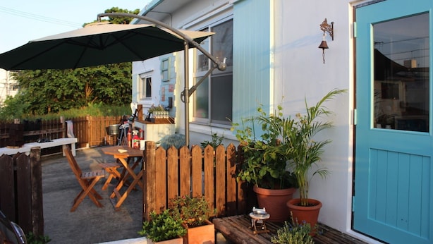 An outdoor patio with a table and chairs, a wooden fence, and potted plants. - Okinawan. Sweet Home.t-8 (Chatan)