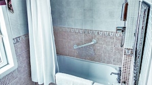 Une salle de bain avec une baignoire, un lavabo et une douche.