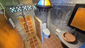 Une salle de bain avec douche, toilettes et lavabo.