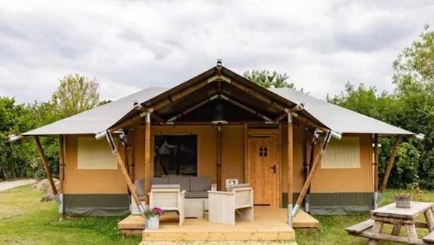 Struttura a forma di A su un unico piano, con veranda, porta e un piccolo angolo relax all'aperto.