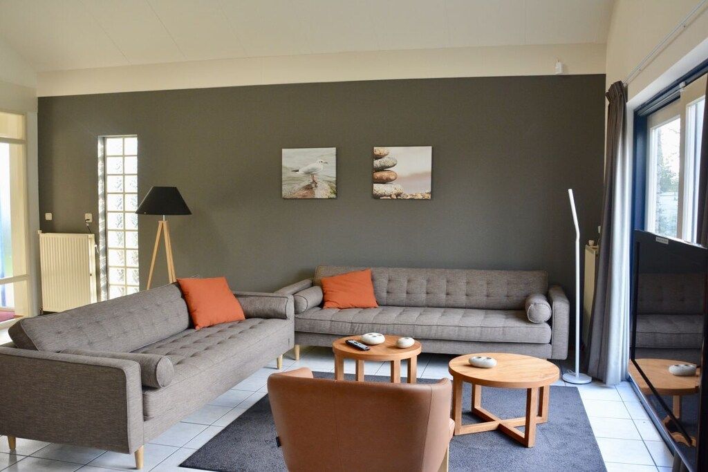 Un salon moderne avec deux canapés, une table basse et un lampadaire.