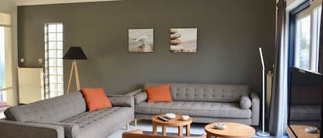 A modern living room with two sofas, a coffee table, and a floor lamp.