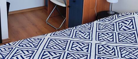A room with a bed, a desk, and a chair.