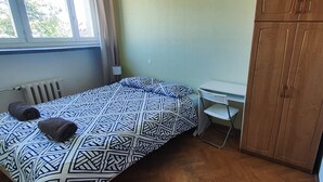 A bedroom with a bed, a desk, and a wardrobe. - Rynek - Nowy Targ (Wrocław)