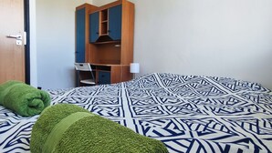 A room with a bed, a green towel, a wooden wardrobe, and a chair. - Rynek - Nowy Targ (Wrocław)