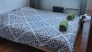 A bedroom with a bed, a window, and a ceiling light fixture. - Rynek - Nowy Targ (Wrocław)