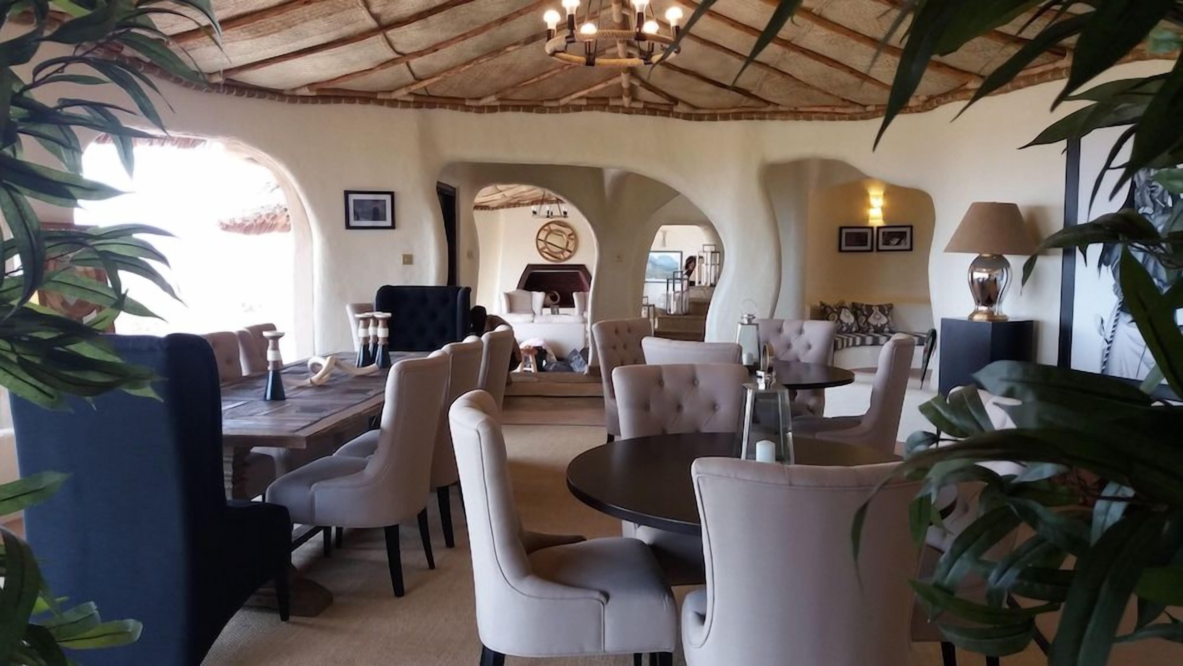 A spacious living area with a high ceiling, comfortable seating, and a dining table.