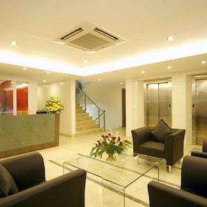 A modern lobby with a reception desk, a staircase, and an elevator. - Oyo Premium Deccan Apte Road (Pune)