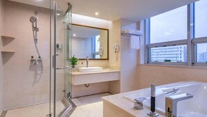 A modern bathroom with a glass shower enclosure, a large bathtub, and a vanity with a mirror. - Vienna International Hotel Guang'anmen (Beijing)