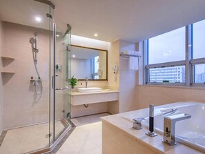 A modern bathroom with a glass shower enclosure, a large bathtub, and a vanity with a mirror. - Vienna International Hotel Guang'anmen (Beijing)