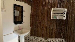 A bathroom with a white sink, a mirror, and a shower curtain. - Jambo Beach Bungalows - Hostel (Paje)