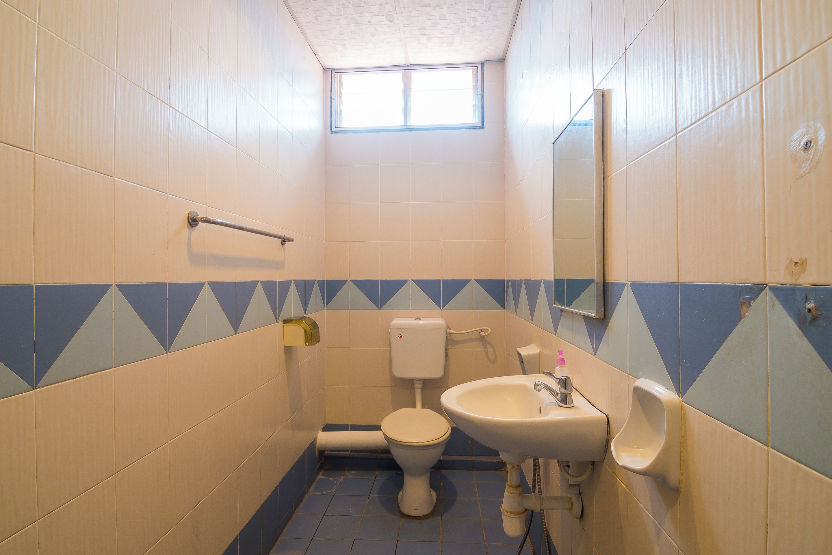 A small bathroom with a toilet, sink, and mirror.