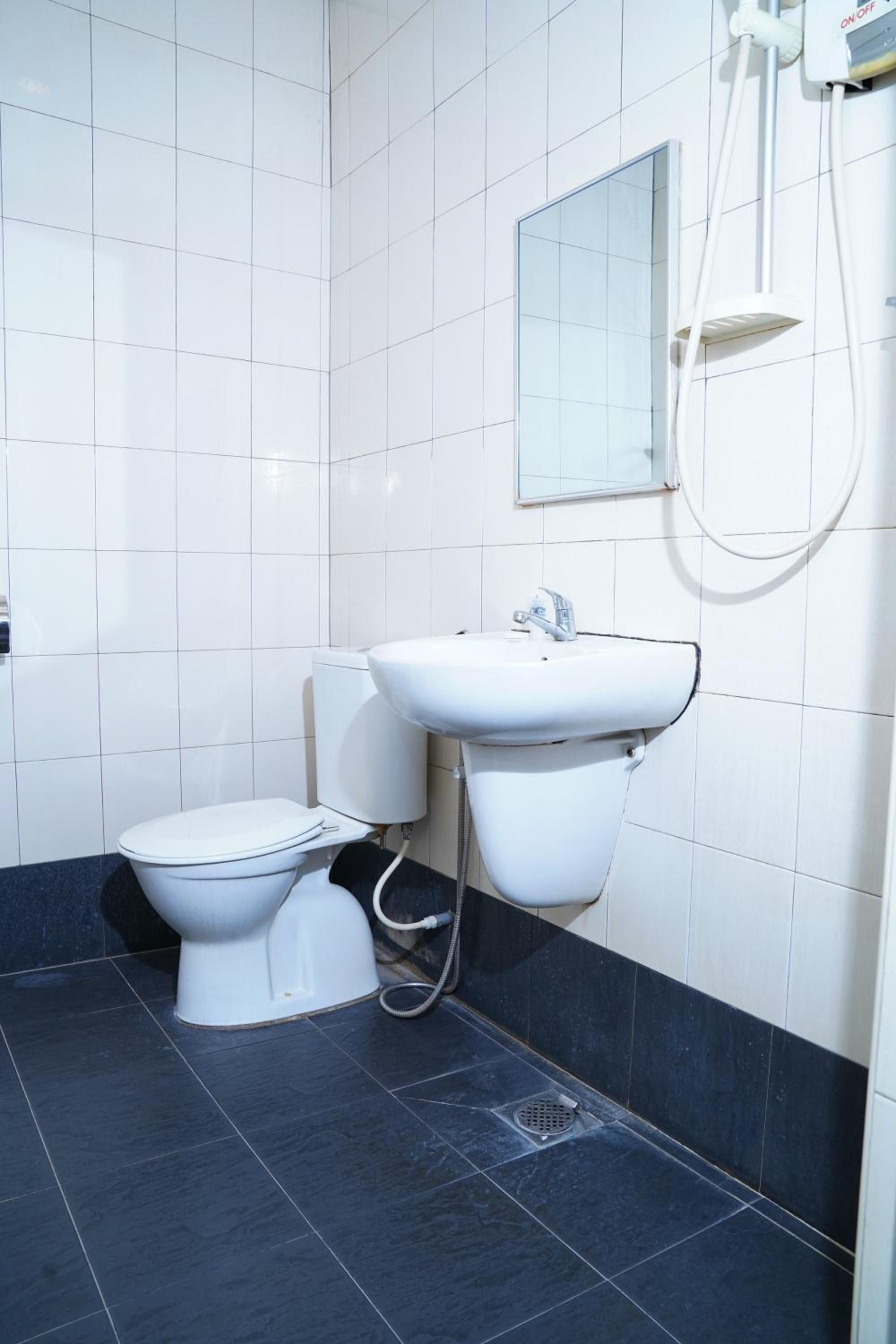 A modern bathroom with a toilet, sink, and shower.