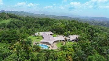A resort with multiple buildings, a swimming pool, and lush greenery.