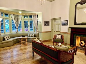 Una habitación tradicional con sofá, sillón y chimenea.
