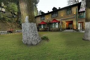 A traditional building with a stone facade, a red-roofed entrance, and a well-maintained lawn. - Brij Villa, Dalhousie (Dalhousie)