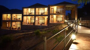 A multi-story building with balconies, a wooden deck, and a stone facade.