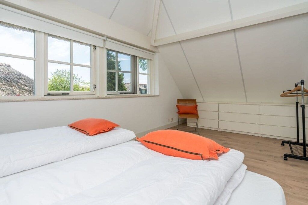 Un dormitorio con dos camas, una ventana y un radiador.