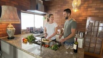A kitchen with a granite countertop, a built-in oven, and a hanging light fixture.